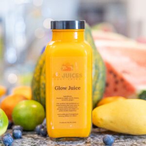 Glow Juice bottle surrounded by fresh fruits